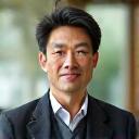 代表取締役 佐藤友明のプロフェッショナルなポートレート。知性と情熱を感じさせる表情。